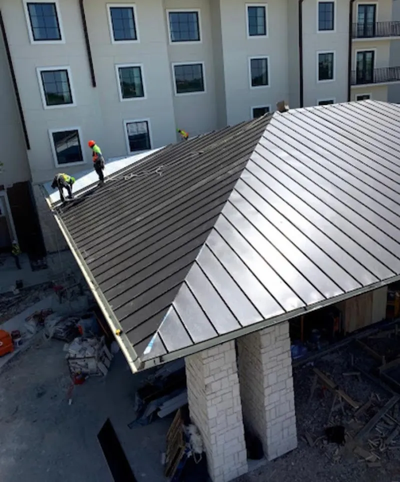 Crew installing standing seam metal roof panels on a commercial project in Jensen Beach
